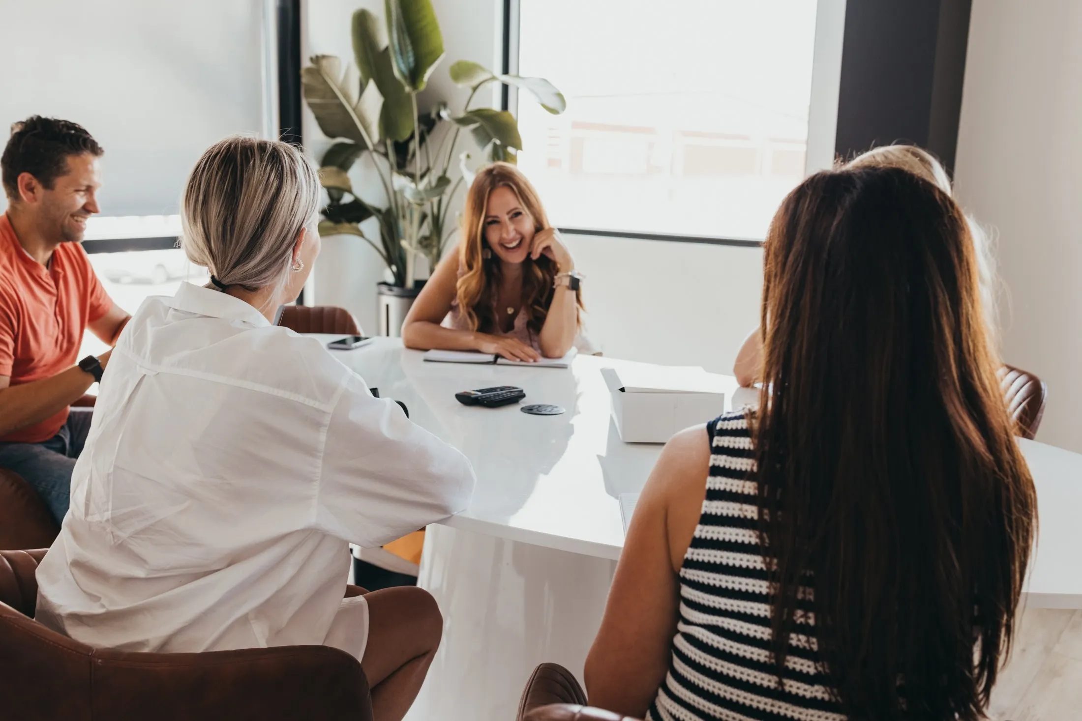 Members laughing together around the boardroom table